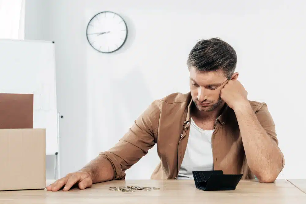Hombre preocupado mirando su cartera vacía, preguntándose si el banco me devuelve el dinero si me estafan y si puedo recuperar mi dinero si me estafaron por transferencia