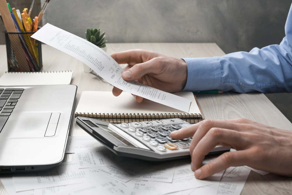 Trabajador realizando el calculo embargo nomina con calculadora y documentación salarial