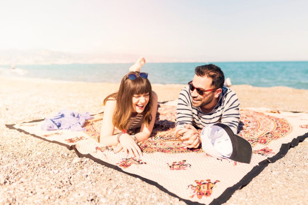 Personas en la playa que piensan en pedir un préstamo urgente para resolver sus deudas tras irse de vacaciones