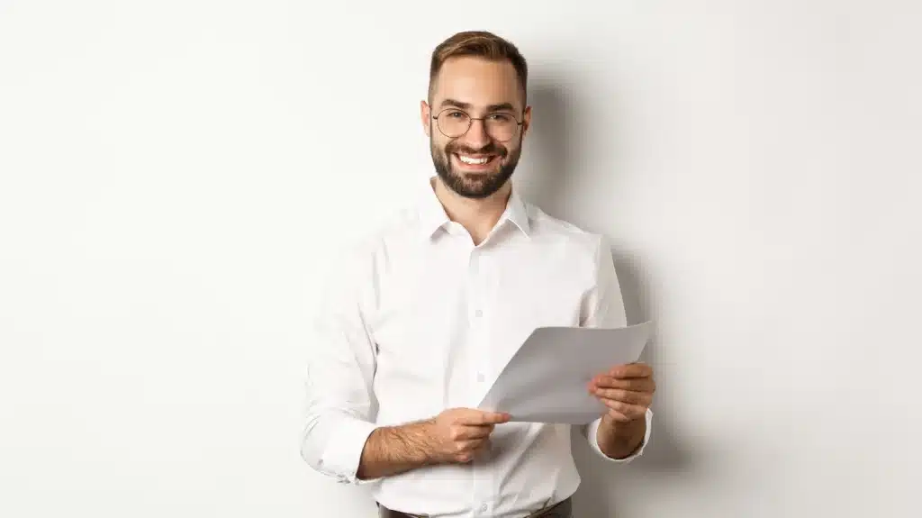 Abogado sonriente con gafas, sosteniendo documentos sobre préstamos ICO últimas noticias.