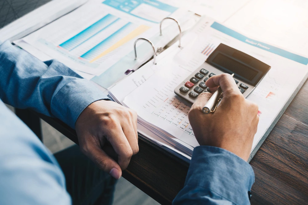 Dos personas revisan gráficos y utilizan una calculadora de embargo de pensiones para calcular los porcentajes legales sobre el exceso del SMI.