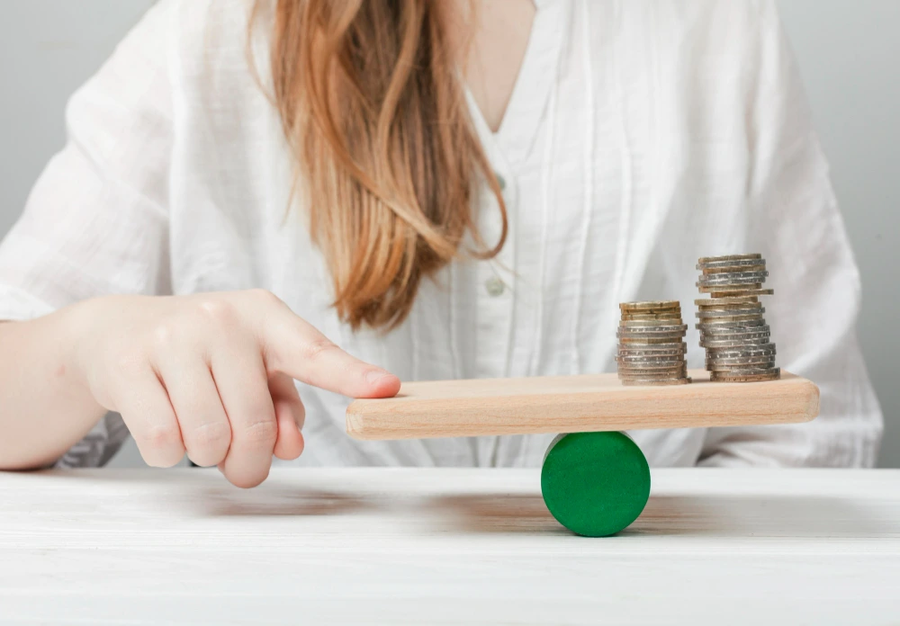 mujer comparando pros y contras con monedas en balanza representando la ley de la segunda oportunidad opiniones