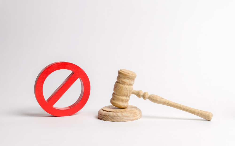 Martillo judicial de madera junto a un símbolo de prohibición, representando la duda frecuente sobre qué pasa si no pagas un préstamo y las consecuencias legales posibles.