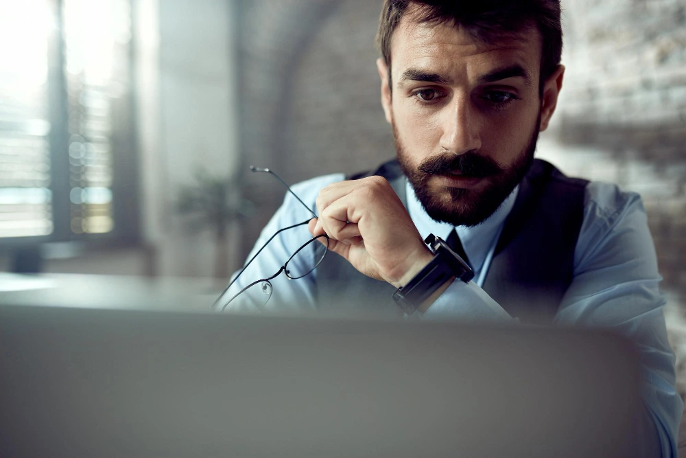 Empresario preocupado frente al ordenador por un posible fraude del CEO