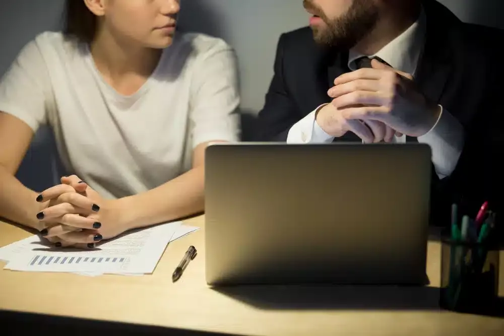 Dos personas hombre y mujer en el escritorio de una entidad bancaria que han solicitado los avales ICO Ucrania, la línea de ayudas ofrecida por el gobierno a través del Instituto de Crédito Oficial para mitigar el impacto de la crisis generada por la guerra de Ucrania