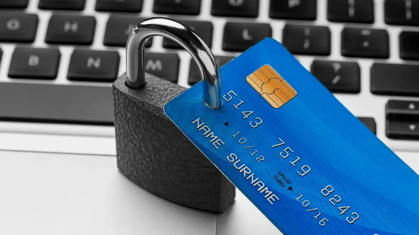 Tarjeta bancaria con candado sobre teclado portátil, simbolizando seguridad financiera ante cobros no autorizados o fraudes cuando me han cobrado algo que no he comprado.