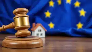 Martillo de juez con casa de fondo emulando a una hipoteca con IRPH y bandera de la UE con motivo de la sentencia europea sobre el irph y su resolución a favor de los afectados consniderándolas nulas y abusivas