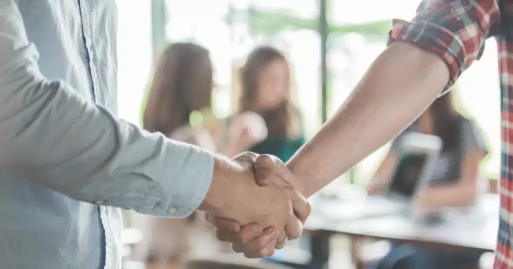 Apretón de manos entre dos personas cerrando un acuerdo, simbolizando una dación en pago entre particulares.
