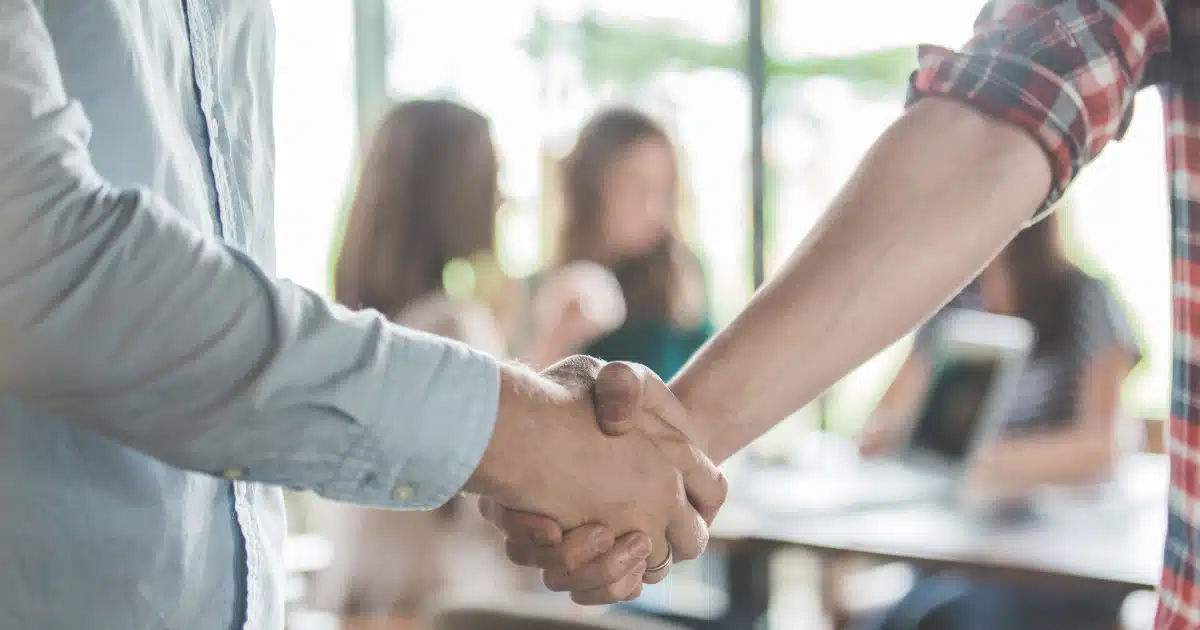 Apretón de manos entre dos personas cerrando un acuerdo, simbolizando una dación en pago entre particulares.
