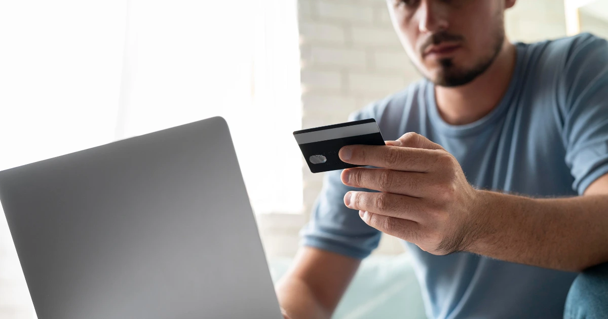 Hombre revisando una compra online con tarjeta frente al ordenador, ilustrando la preocupación sobre dónde denunciar una compra por internet que no llega.