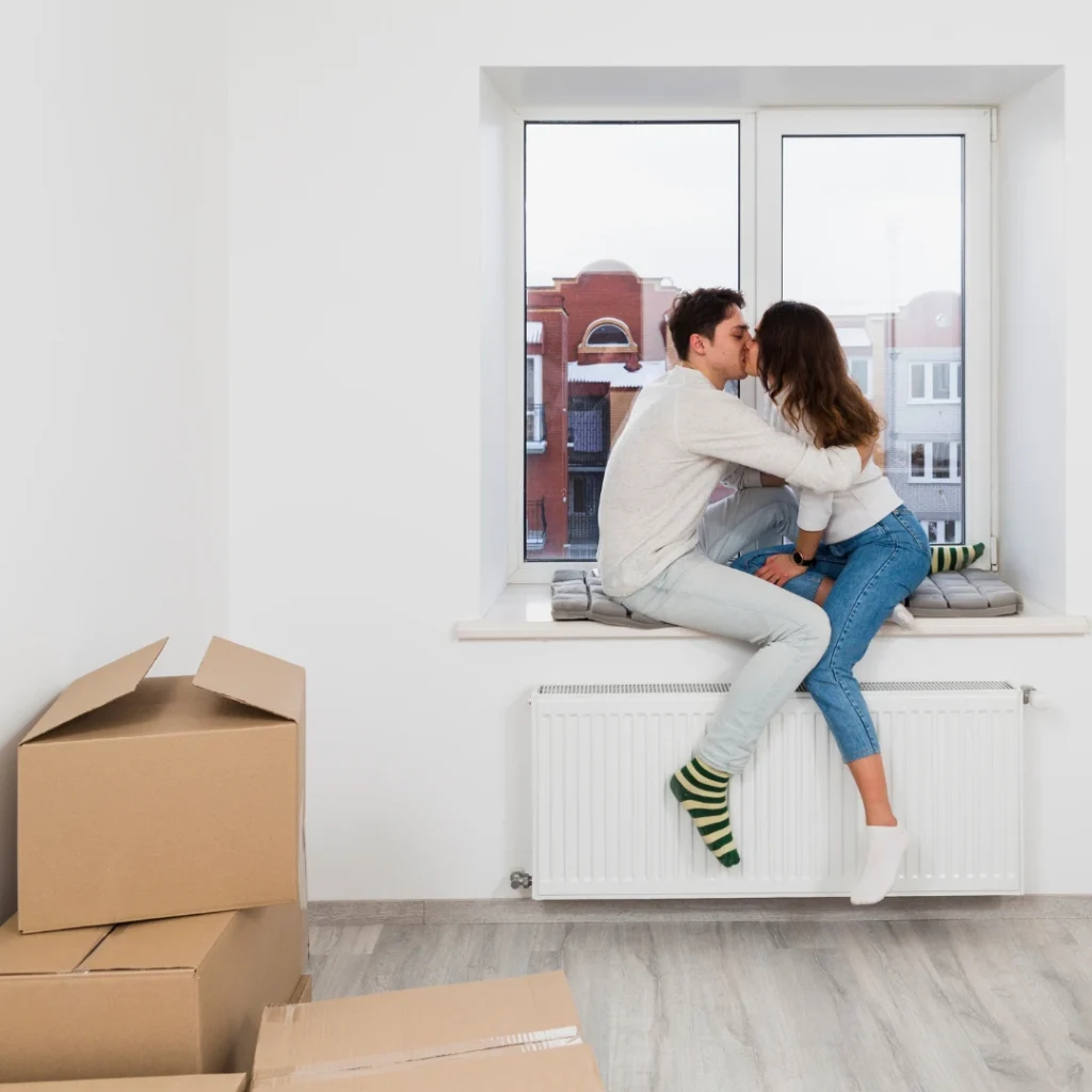 Pareja feliz en su nuevo hogar tras acogerse a vías legales para evitar el desahucio y conservar su vivienda.