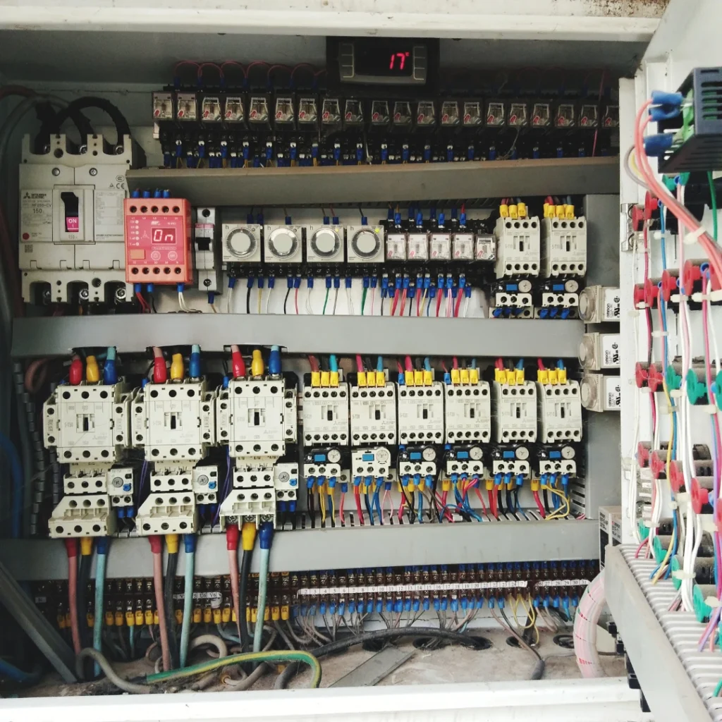 Panel de control eléctrico industrial con cableado y componentes que muestran una posible causa de avería eléctrica en sistemas eléctricos complejos.