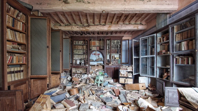 Interior de una librería antigua saqueada tras un robo en local comercial con libros y estanterías en desorden.