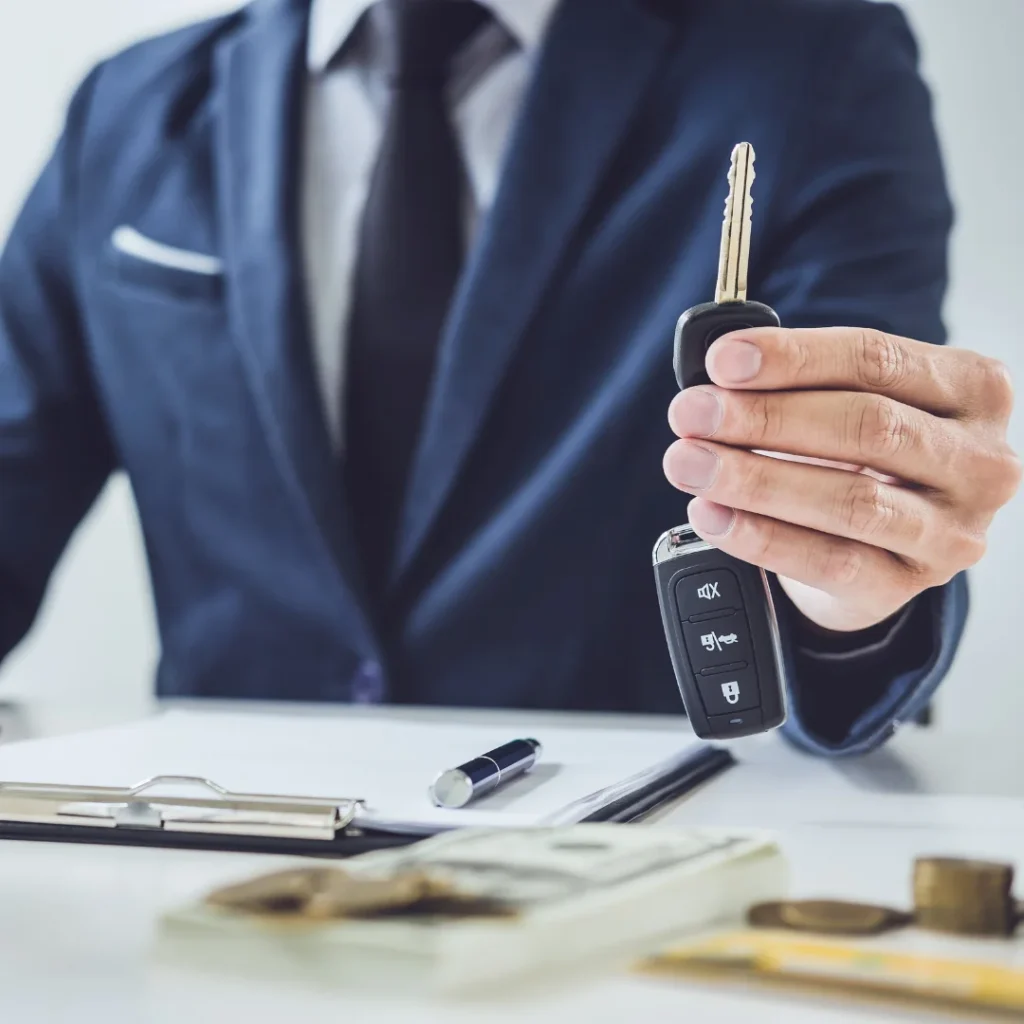 Abogado mostrando las llaves de un coche mientras asesora a un cliente sobre los derechos y obligaciones en un contrato de renting.