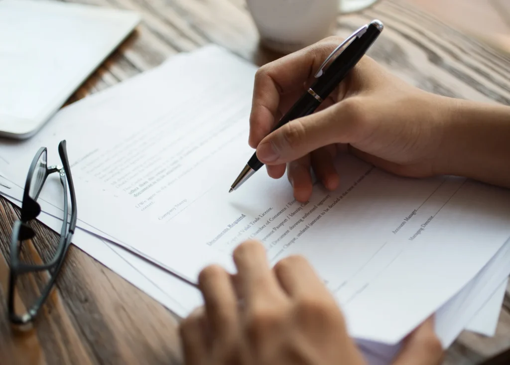 Persona firmando un documento que representa un contrato como título no judicial, con valor ejecutivo según la Ley de Enjuiciamiento Civil.