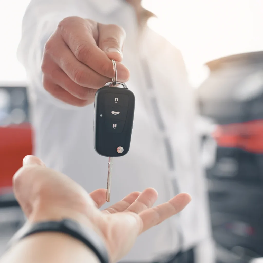 Entrega de llaves de un coche entre dos personas, representando una situación de embargo o conflicto legal sobre un vehículo de renting para quien se pregunta si me pueden embargar un coche de renting.