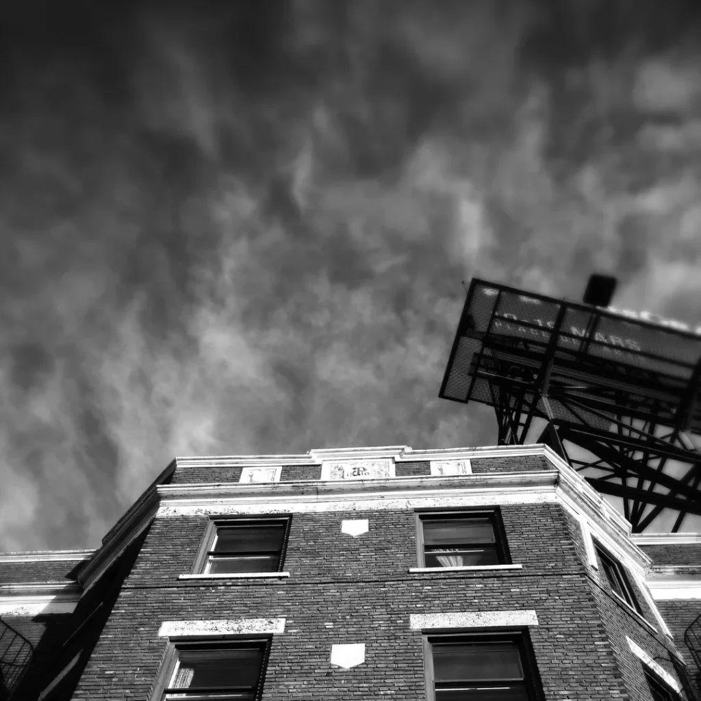 Edificio de viviendas afectado por un incendio, visto desde la calle, con humo en el cielo simbolizando los daños estructurales tras un siniestro en el hogar.