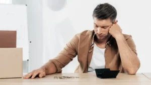 Hombre desempleado mirando su cartera vacía sobre una mesa, representando la búsqueda de préstamos para desempleados en España y las dificultades financieras que pueden resolverse mediante la Ley de Segunda Oportunidad.