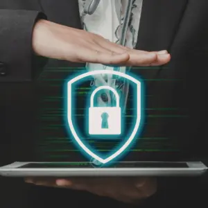 Abogado especializado en protección de datos sosteniendo una tableta con un icono de ciberseguridad, símbolo del ciberataque a Energía XXI y la necesidad de reclamar por la filtración de información personal.