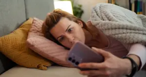 Mujer preocupada mirando su móvil tras recibir una llamada sospechosa, representando una estafa telefónica con IA o intento de fraude mediante suplantación de identidad.