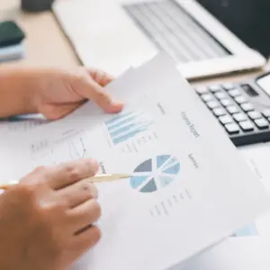 Persona analizando informes financieros para calcular el lucro cesante tras una pérdida económica.